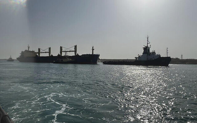 Bulk carrier ship Xin Hai Tong 23, left, is towed after it ran aground at the southern mouth of the Suez Canal in Egypt, May 25, 2023. (Suez Canal Authority via AP)
