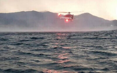 In this image released by the Italian firefighters, a helicopter searches for missing passengers after a tourist boat capsized in a storm on Italy's Lago Maggiore in the northern Lombardy region, May 28, 2023. (Vigili Del Fuoco via AP)
