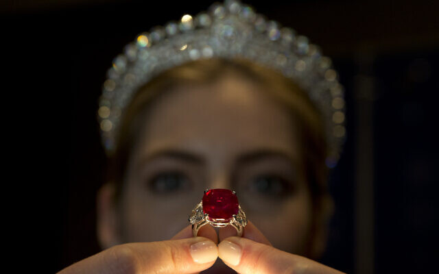 An employee of Sotheby's auction house holds up the 'Sunrise Ruby' ring, a cushion shaped Myanmar ruby of some 25.59 carats of pigeon blood colour during a photocall in London, April 8, 2015. (Alastair Grant/AP) An employee of Sotheby's auction house holds up the 'Sunrise Ruby' ring, a cushion shaped Myanmar ruby of some 25.59 carats of pigeon blood colour during a photocall in London, April 8, 2015. (Alastair Grant/AP)