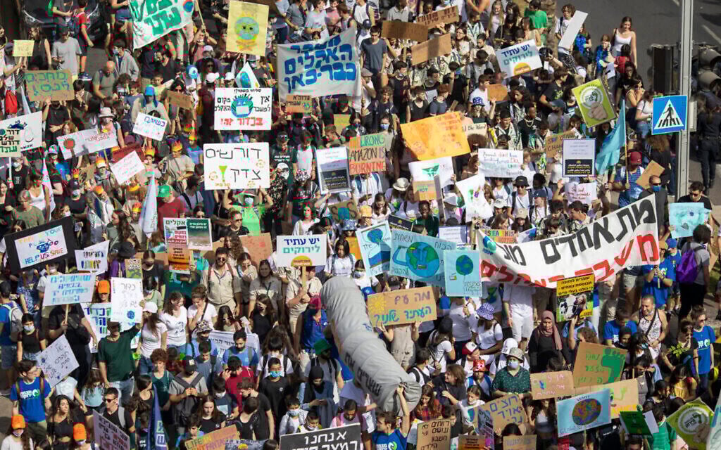 People holding banners march to demand world leaders to take action in reversing climate change and stop the use of fossil fuels during a rally in Tel Aviv, Israel, Friday, Oct. 29, 2021.  (AP Photo/Ariel Schalit)