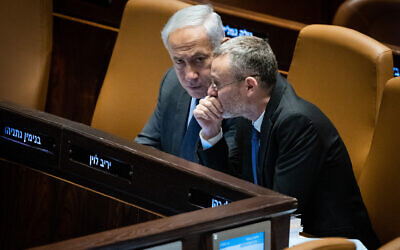 Prime Minister Benjamin Netanyahu, left, speaks with Justice Minister Yariv Levin at the Knesset plenum in Jerusalem, March 27, 2023. (Yonatan Sindel/Flash90)