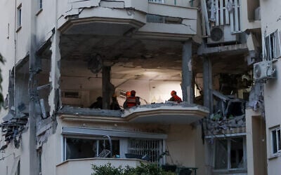 Police and rescue forces at the scene where a rocket fired from Gaza hit and damaged a building in Rehovot on May 11, 2023. (Yossi Aloni/Flash90)