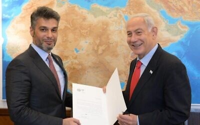 Prime Minister Benjamin Netanyahu (R) receives an invitation to the COP28 climate summit in November in Dubai from Mohamed Al Khaja, the UAE ambassador to Israel, May 25, 2023 (Amos Ben Gershom/GPO)