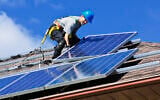 Installing solar panels on a roof. (Elenathewise, iStock at Getty Images)