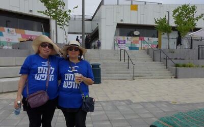 Tirtza Carmi, a resident of Harish, and a friend wear t-shirts reading, 'Freedom fighter' to a demonstration against religious coercion in Harish, Israel, on May 27, 2023. (Canaan Lidor/Times of Israel)
