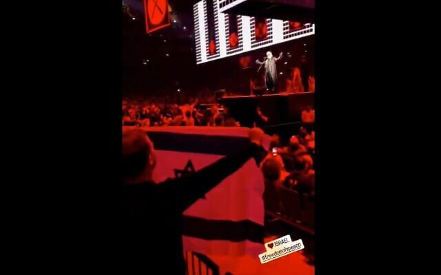 Filmmaker Emilio Schenker displays an Israeli flag at a Roger Waters concert at the O2 Arena in London, United Kingdom, June 7, 2023. (Twitter video screenshot: used in accordance with Clause 27a of the Copyright Law) Filmmaker Emilio Schenker displays an Israeli flag at a Roger Waters concert at the O2 Arena in London, United Kingdom, June 7, 2023. (Twitter video screenshot: used in accordance with Clause 27a of the Copyright Law)
