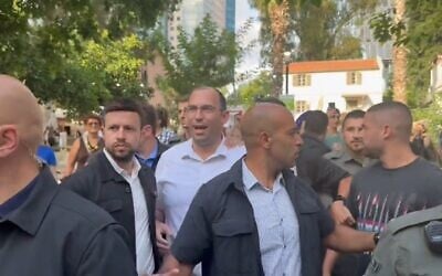 Religious Zionism MK Simcha Rothman leaving the Hebrew Book Week Fair amid anti-judicial overhaul protests at Sarona Market, Tel Aviv, June 18, 2023. (Twitter video screenshot: used in accordance with Clause 27a of the Copyright Law)