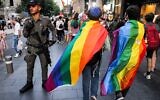 File - A Border Police officer stands guard as people draped in rainbow flags march during the 21st annual Jerusalem Pride Parade in Jerusalem on June 1, 2023. (Menahem KAHANA / AFP)
