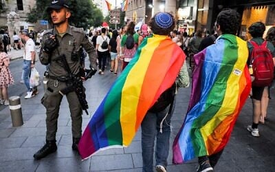 File - A Border Police officer stands guard as people draped in rainbow flags march during the 21st annual Jerusalem Pride Parade in Jerusalem on June 1, 2023. (Menahem KAHANA / AFP)