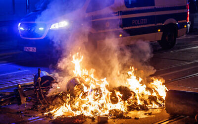 Trashcans burn in a street during a protest organised by far-left activists in Leipzig, eastern Germany, on June 3, 2023  (JENS SCHLUETER/AFP)