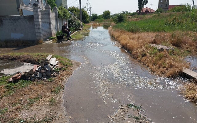 A man sits on a bench outside his building outskirt of partially flooded Kherson on June 6, 2023, after a Russian-held dam in southern Ukraine was damaged. (Sergiy Dollar / AFP) A man sits on a bench outside his building outskirt of partially flooded Kherson on June 6, 2023, after a Russian-held dam in southern Ukraine was damaged. (Sergiy Dollar / AFP)