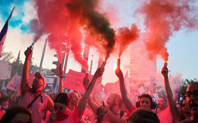 Demonstrators hold up flares during a rally to protest the government's judicial overhaul plans, in Tel Aviv, on June 10, 2023. (Jack Guez/AFP)