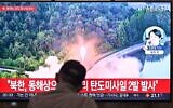 A man watches a television showing a news broadcast with file footage of a North Korean missile test, at a railway station in Seoul on June 15, 2023. (Photo by Anthony WALLACE / AFP)