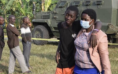 A boy is comforted at the scene of an attack in Mpondwe, Uganda, on June 17, 2023, at the Mpondwe Lhubiriha Secondary School. (AFP)