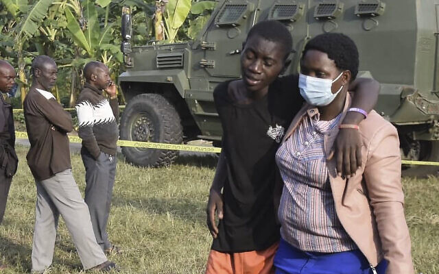 A boy is comforted at the scene of an attack in Mpondwe, Uganda, on June 17, 2023, at the Mpondwe Lhubiriha Secondary School. (AFP)