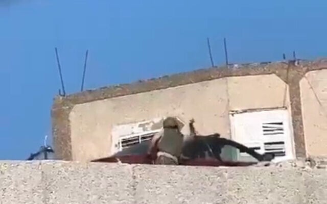 An IDF soldier is seen vandalizing a Palestinian-owned car in the West Bank village of Qaryut, June 30, 2023. (Courtesy) An IDF soldier is seen vandalizing a Palestinian-owned car in the West Bank village of Qaryut, June 30, 2023. (Courtesy)