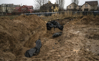lie in a mass grave in Bucha, on the outskirts of Kyiv, Ukraine, after it was retaken from Russian forces, April 3, 2022. (Rodrigo Abd/AP)