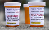 Fake pill bottles with messages about OxyContin maker Purdue Pharma are displayed during a protest outside the courthouse where the bankruptcy of the company is taking place in White Plains, NY, on Aug. 9, 2021. (AP/Seth Wenig)