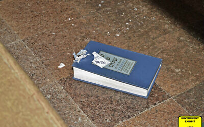 This image released by the Department of Justice shows a bullet-damaged prayer book that was introduced as a court exhibit, Tuesday, May 30, 2023, in the federal trial of Robert Bowers in Pittsburgh. (Department of Justice via AP)
