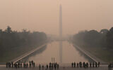 With the Washington Monument in the background and a thick layer of smoke, Marine Corps honor color guard rehearse, Thursday, June 8, 2023, in Washington (AP Photo/Jose Luis Magana)