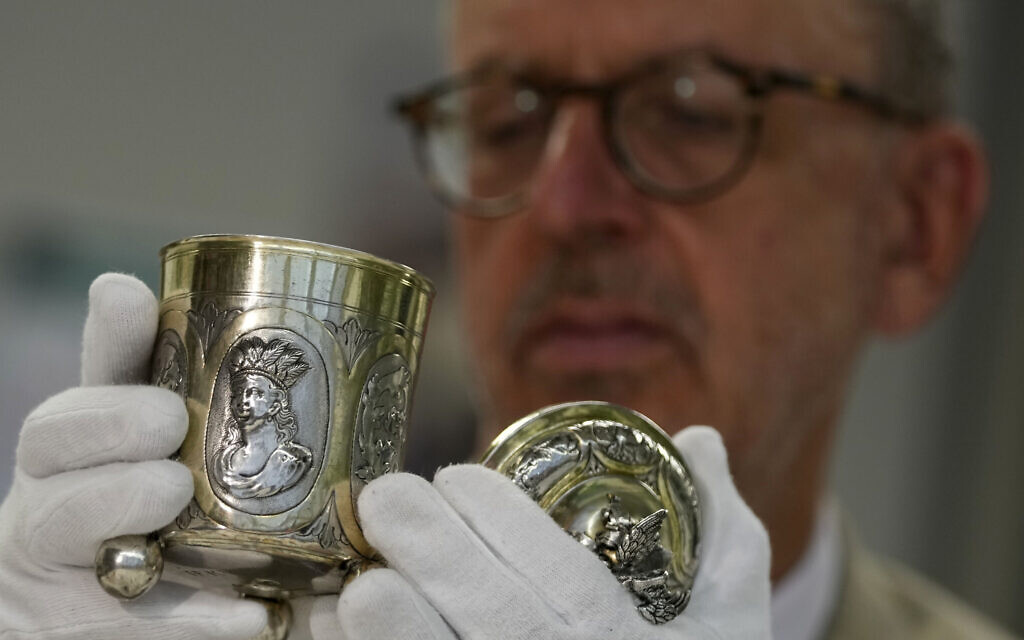 Matthias Weniger, curator of the Bavarian National Museum, lifts one of 111 silver objects, stolen by the Nazis from Jews during the Third Reich, in Munich, Germany, June 10, 2023. (AP Photo/Matthias Schrader) Matthias Weniger, curator of the Bavarian National Museum, lifts one of 111 silver objects, stolen by the Nazis from Jews during the Third Reich, in Munich, Germany, June 10, 2023. (AP Photo/Matthias Schrader)