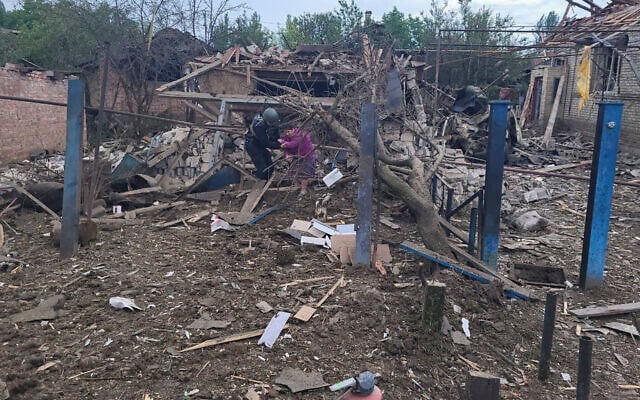 A Ukrainian police officer helps a local resident to leave her house ruined in the deadly morning Russian rocket attack in Kostyantynivka, Donetsk region, Ukraine, Wednesday, June 14, 2023. (Ukrainian Donetsk Regional Administration via AP)