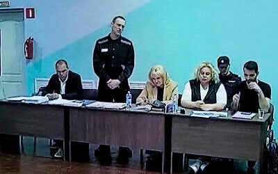 A TV Screen showing Russian opposition leader Alexei Navalny, 2nd left, between his lawyers in a courtroom, via video link provided by the Russian Federal Penitentiary Service, during a preliminary hearing, in Melekhovo, Vladimir region, Russia, June 19, 2023. (AP Photo/Alexander Zemlianichenko)