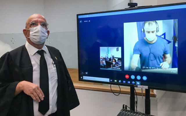 On screen: Yotam Okon, a teacher, suspected of raping his 12-year-old student, appears virtually during a hearing at the Tel Aviv Magistrate's Court, October 4, 2021, alongside attorney Sassy Gez. (Avshalom Sassoni/Flash90) On screen: Yotam Okon, a teacher, suspected of raping his 12-year-old student, appears virtually during a hearing at the Tel Aviv Magistrate's Court, October 4, 2021, alongside attorney Sassy Gez. (Avshalom Sassoni/Flash90)