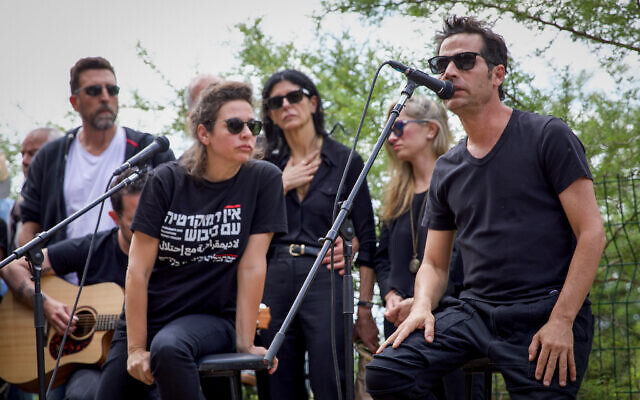 Shira Geffen, center left, at the funeral of her father author and musician Yehonatan Geffen in Nahalal cemetery, northern Israel, April 21, 2023. Shira Geffen's T-shirt reads 'No democracy with occupation.' (Shir Torem/Flash90 ) Shira Geffen, center left, at the funeral of her father author and musician Yehonatan Geffen in Nahalal cemetery, northern Israel, April 21, 2023. Shira Geffen's T-shirt reads 'No democracy with occupation.' (Shir Torem/Flash90 )