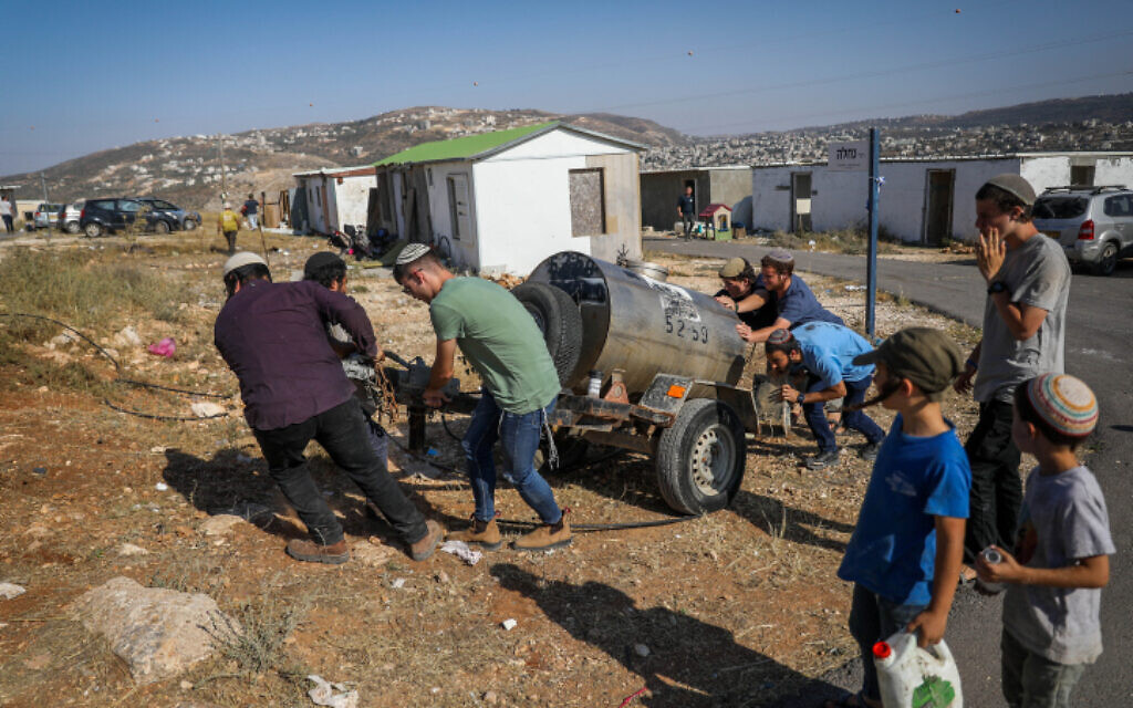 Youths at the illegal West Bank outpost of Evyatar bring in a water tanker, June 22, 2023. (Flash90) Youths at the illegal West Bank outpost of Evyatar bring in a water tanker, June 22, 2023. (Flash90)