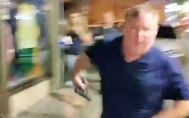 Screen capture from video of a man pulling out a pistol during a confrontation with an anti-government protester in Petah Tikva, JUne 26, 2023. (Twitter. Used in accordance with Clause 27a of the Copyright Law) Screen capture from video of a man pulling out a pistol during a confrontation with an anti-government protester in Petah Tikva, JUne 26, 2023. (Twitter. Used in accordance with Clause 27a of the Copyright Law)