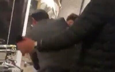 Religious Zionism MK Simcha Rothman (C) scuffles with a protester in New York as he grabs her megaphone on June 2, 2023. (Screenshot used in accordance with Clause 27a of the Copyright Law)