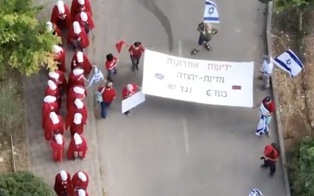 A screenshot from video of a protest outside Social Equality Minister Amichai Chikli's home at Kibbutz Hanaton in northern Israel shows protesters wearing costumes from "The Handmaid's Tale," June 30, 2023. (Twitter. Used in accordance with Clause 27a of the Copyright Law) A screenshot from video of a protest outside Social Equality Minister Amichai Chikli's home at Kibbutz Hanaton in northern Israel shows protesters wearing costumes from "The Handmaid's Tale," June 30, 2023. (Twitter. Used in accordance with Clause 27a of the Copyright Law)