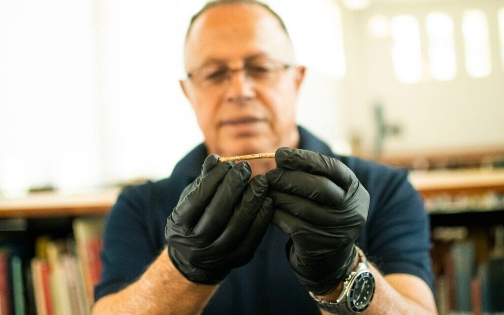 Dr. Hamoudi Khalaily holds the original 12,000-year-old flute discovered in a Natufian village in northern Israel. (Hamoudi Khalaily/IAA)