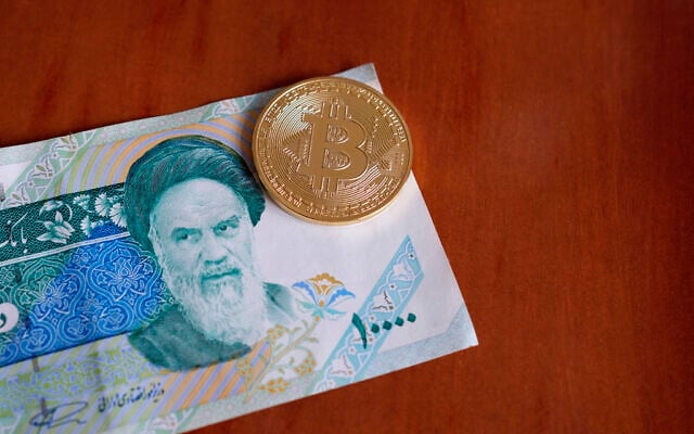 Illustrative: A coin bearing the Bitcoin logo, above a 10,000 Rial banknote. (Rainer Puster/iStock Photo by Getty Images)
