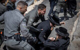 Ultra-Orthodox Jewish men clash with police during a protest against the construction work for the Jerusalem light rail, in Jerusalem, June 7, 2023. (Yonatan Sindel/Flash90)
