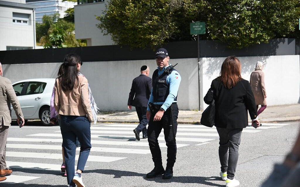 A police officer blocks a road for visitors of the Kadoorie Synagogue in Porto, Portugal on May 16, 2023. (Eli Mandelbaum/EJA) A police officer blocks a road for visitors of the Kadoorie Synagogue in Porto, Portugal on May 16, 2023. (Eli Mandelbaum/EJA)