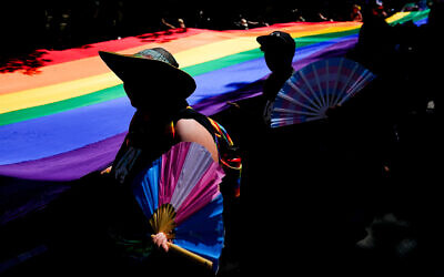 Illustrative: Marchers hold transgender pride fans as they help carry a large rainbow flag at the annual Seattle Pride Parade, in Seattle, Washington, June 25, 2023. (AP Photo/Lindsey Wasson)