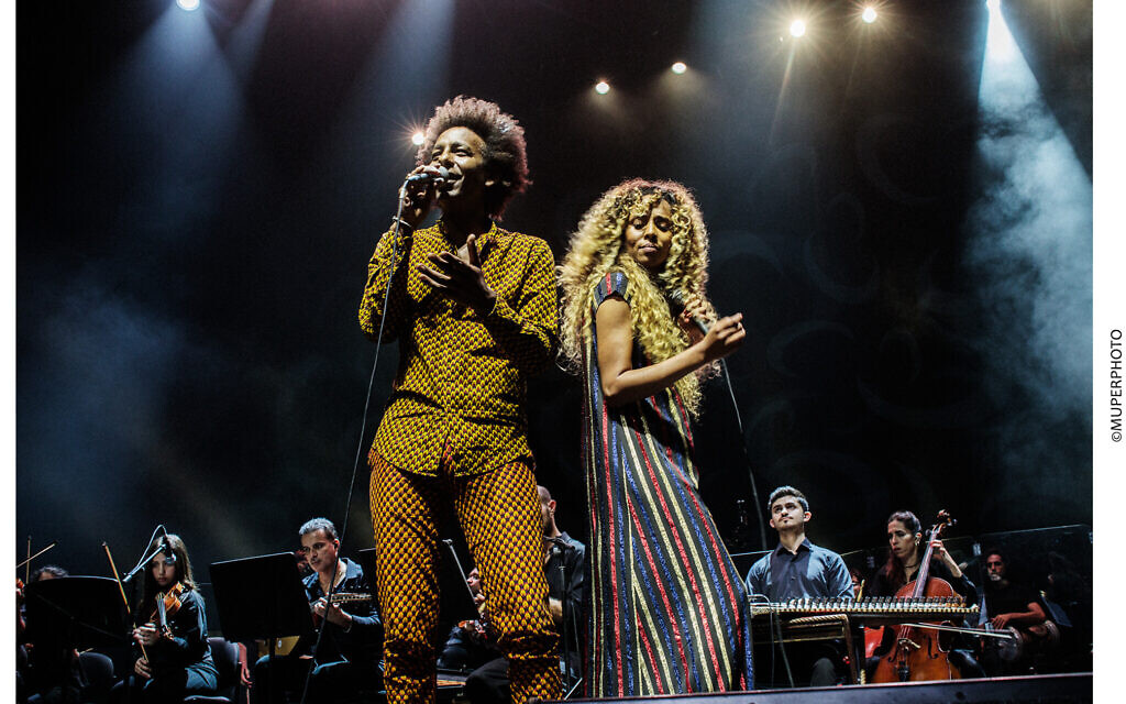 Gili Yalo (left) and Ester Rada (right) perform in 'Tazeta,' ('Nostalgia' in Amharic), a concert melding the sounds of jazz and pop from Ethiopian music, with conductor Tom Cohen and his East-West Orchestra on July 10, 2023 (Courtesy Israeli Opera) Gili Yalo (left) and Ester Rada (right) perform in 'Tazeta,' ('Nostalgia' in Amharic), a concert melding the sounds of jazz and pop from Ethiopian music, with conductor Tom Cohen and his East-West Orchestra on July 10, 2023 (Courtesy Israeli Opera)