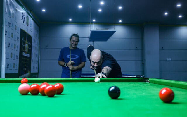 A man plays snooker at a club in Tehran on June 26, 2023. (ATTA KENARE / AFP)