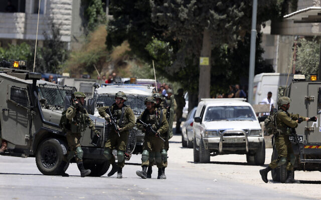 Israeli soldiers take position in the West Bank village of Orif, south of Nablus, as they engage in a search operation for wanted Palestinians, on June 29, 2023. (Jaafar Ashtiyeh AFP) Israeli soldiers take position in the West Bank village of Orif, south of Nablus, as they engage in a search operation for wanted Palestinians, on June 29, 2023. (Jaafar Ashtiyeh AFP)