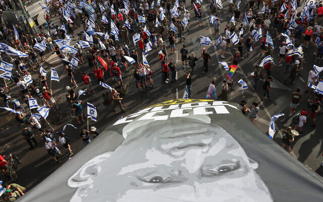 Demonstrators lift a large banner as they stage a protest the government's judicial overhaul plans, in Tel Aviv on July 18, 2023. (JACK GUEZ/AFP) Demonstrators lift a large banner as they stage a protest the government's judicial overhaul plans, in Tel Aviv on July 18, 2023. (JACK GUEZ/AFP)