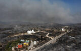 An aerial view shows smoke billowing in background of Kiotari village, on the island of Rhodes on July 24, 2023.(Spyros BAKALIS / AFP)