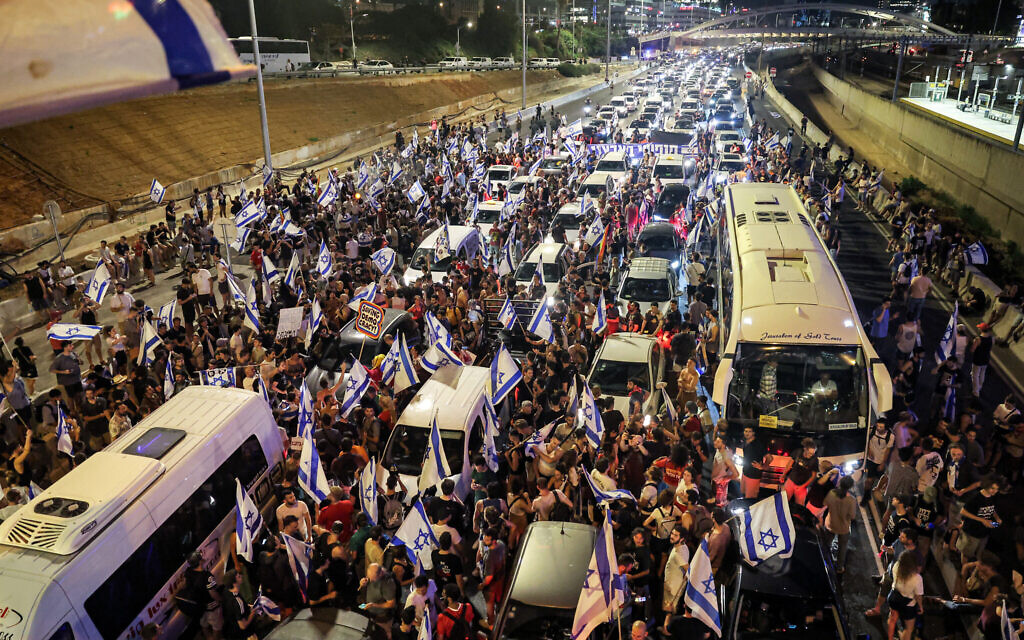 Demonstrators stand amid the traffic as they block the Ayalon Highway during a protest rally against the government's judicial overhaul, in Tel Aviv on July 24, 2023. (Jack Guez / AFP)
