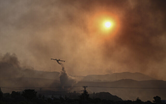 A Canadair firefighting airplane sprays water on a fire in Gennadi, on the southern part of the Greek island of Rhodes on July 25, 2023, on July 25, 2023, during a wildfire (Spyros Bakalis/AFP)