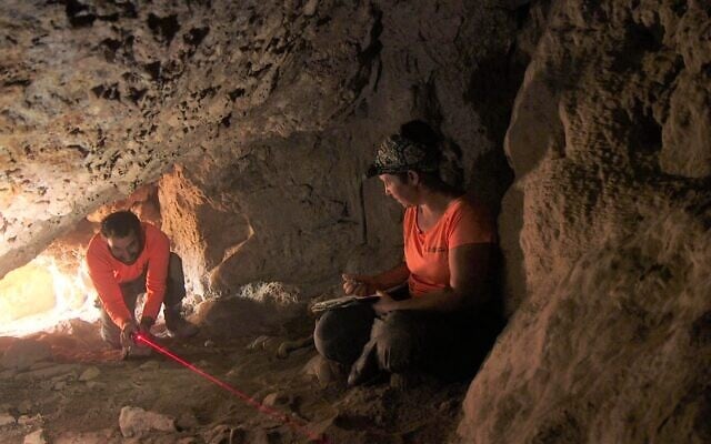 Ouria Amichai and said Hagay Hamer, of the  IAA’s Judean Desert Survey, explore a cave near Ein Gedi. (Emil Aladjem/IAA)