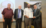 Former Times of Israel correspondent Judah Ari Gross, second right, receives a certificate of merit from B'nai B'rith World Center for his reporting on Diaspora Jewry, in Jerusalem,July 4, 2023. (Bruno Charbit)