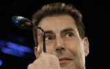 Magician Uri Geller poses for photographers with a bent spoon in Cologne, Germany, Sunday January 6, 2008. (AP Photo/Hermann J. Knippertz)
