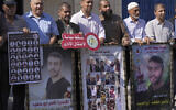 Illustrative: Protesters carry pictures of various Palestinian security prisoners, left and center, who are being held in administrative detention and posters of prisoner Nasser Abu Hmeid, right and second left, who is reported to be critically ill and serving several life sentences and an additional 50 years, during a protest against the Israeli administrative detention policy, in front of the Office of the United Nations High Commissioner for Human Rights in Gaza City, October 12, 2022. Arabic on the red banner reads: “Down with the administrative detention." (AP Photo/Adel Hana)
