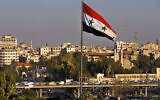 A Syrian national flag waves as vehicles move slowly on a bridge during rush hour, in Damascus, Syria, on February 28, 2016. (Hassan Ammar/AP)